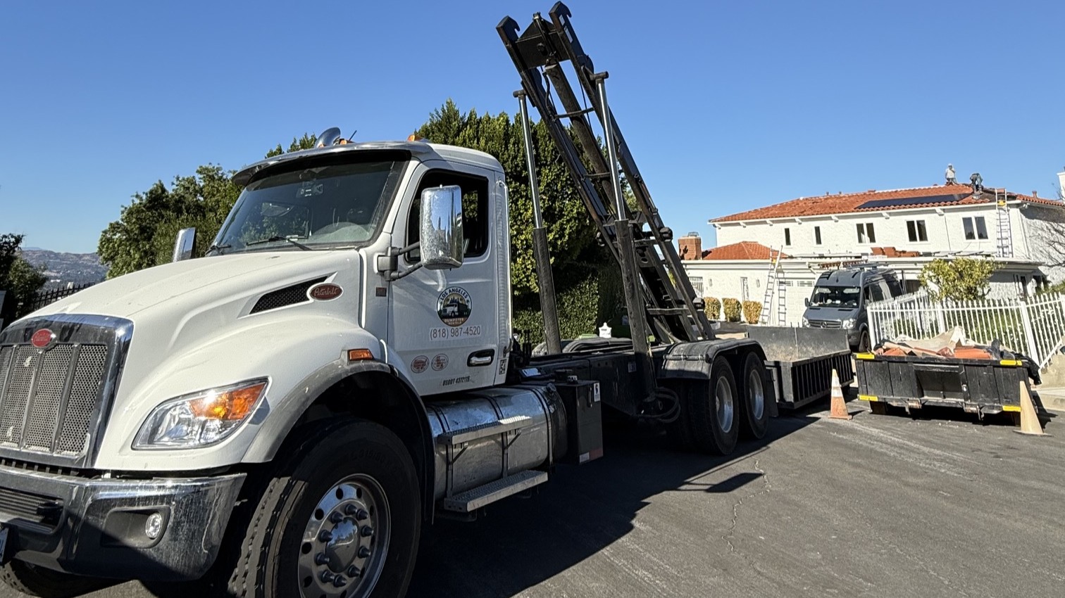 Los Angeles Dumpster Rentals truck delivering a bin to a residential home